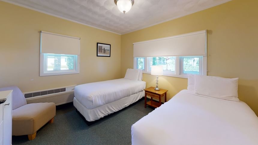 Two beds with table lamp by the window and couch in Nick Cottage at Breezeway Boutique Hotel
