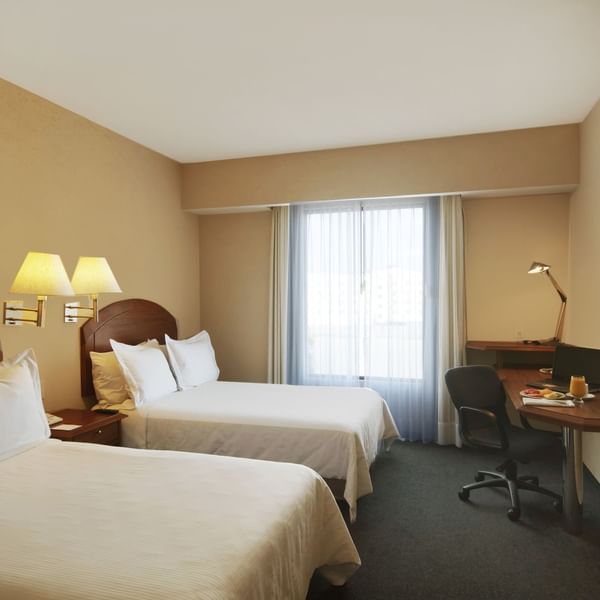 Twin beds with working desk In Superior Room at Fiesta Inn