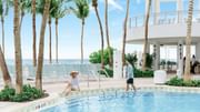 Couple relaxing in Sparkling Lagoon Pool with ocean view at Diplomat Beach Resort