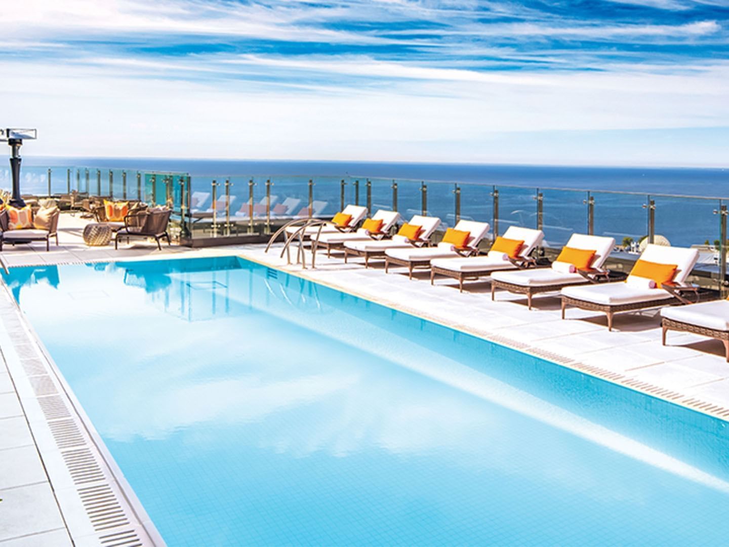 Hotel X Toronto rooftop pool with loungers overlooking the ocean under a blue sky at Hotel X Toronto
