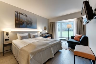 Modern Classic Single or ​Double Hillside View at Tyrifjord Hotel with two beds, a balcony, and artwork above the headboard