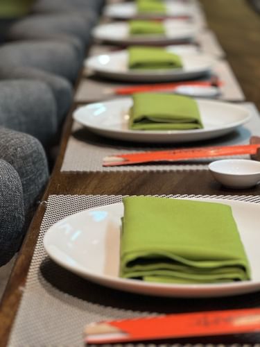 Green napkins by white plates near grey dining chairs in Sazanami at Warwick Fiji Resort and Spa
