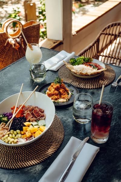 Poke bowl and fried appetizers on an outdoor dining table at Barefoot Cay Resort & Marina
