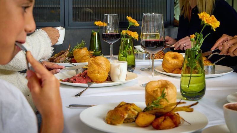 Family enjoying a roast dinner, Yorkshire puddings, red wine at Whitcomb's.