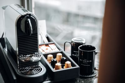 Nespresso machine with coffee pods, sweeteners, and two mugs in Executive Suite at The St. Regis Hotel Vancouver