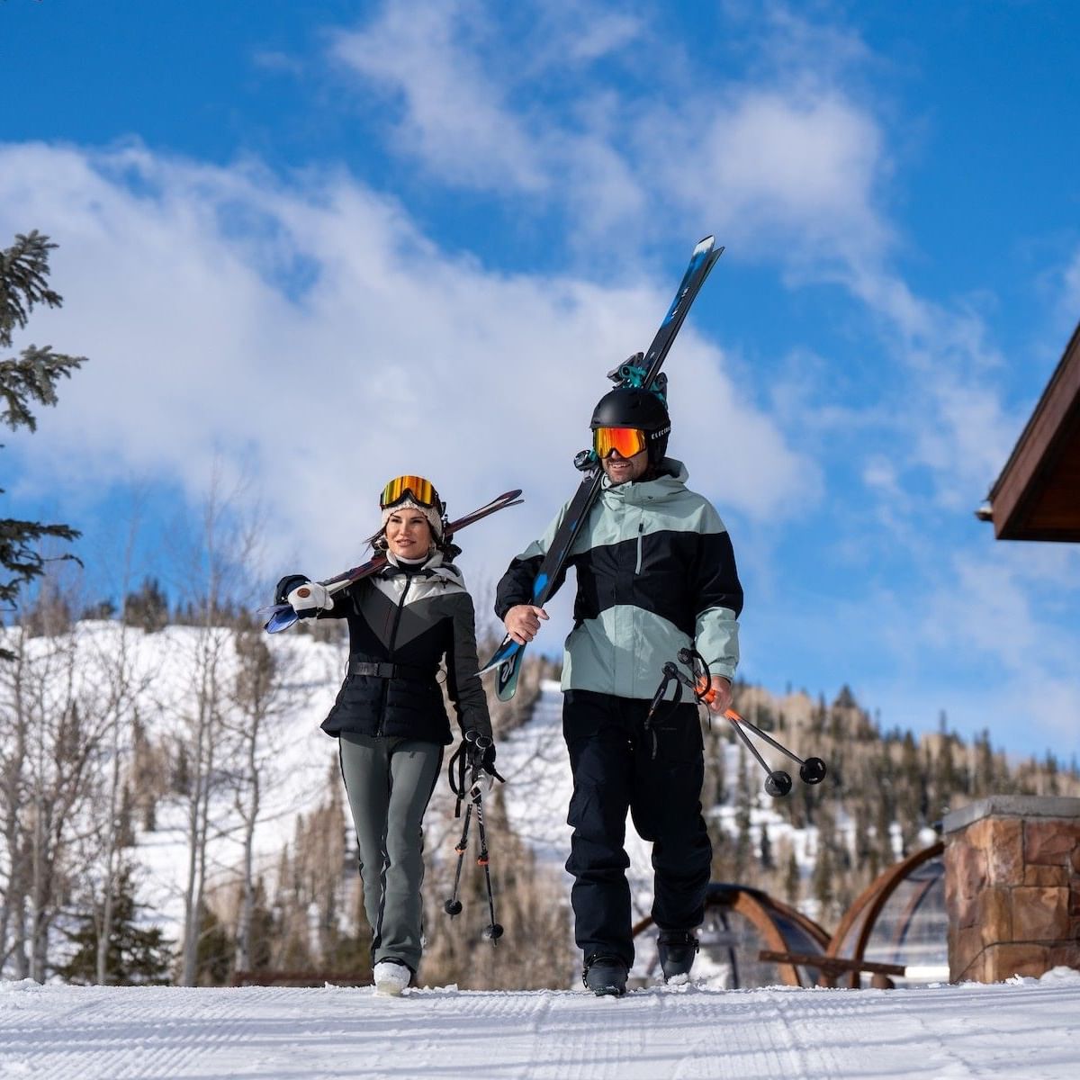 Bluebird day couple carrying skis