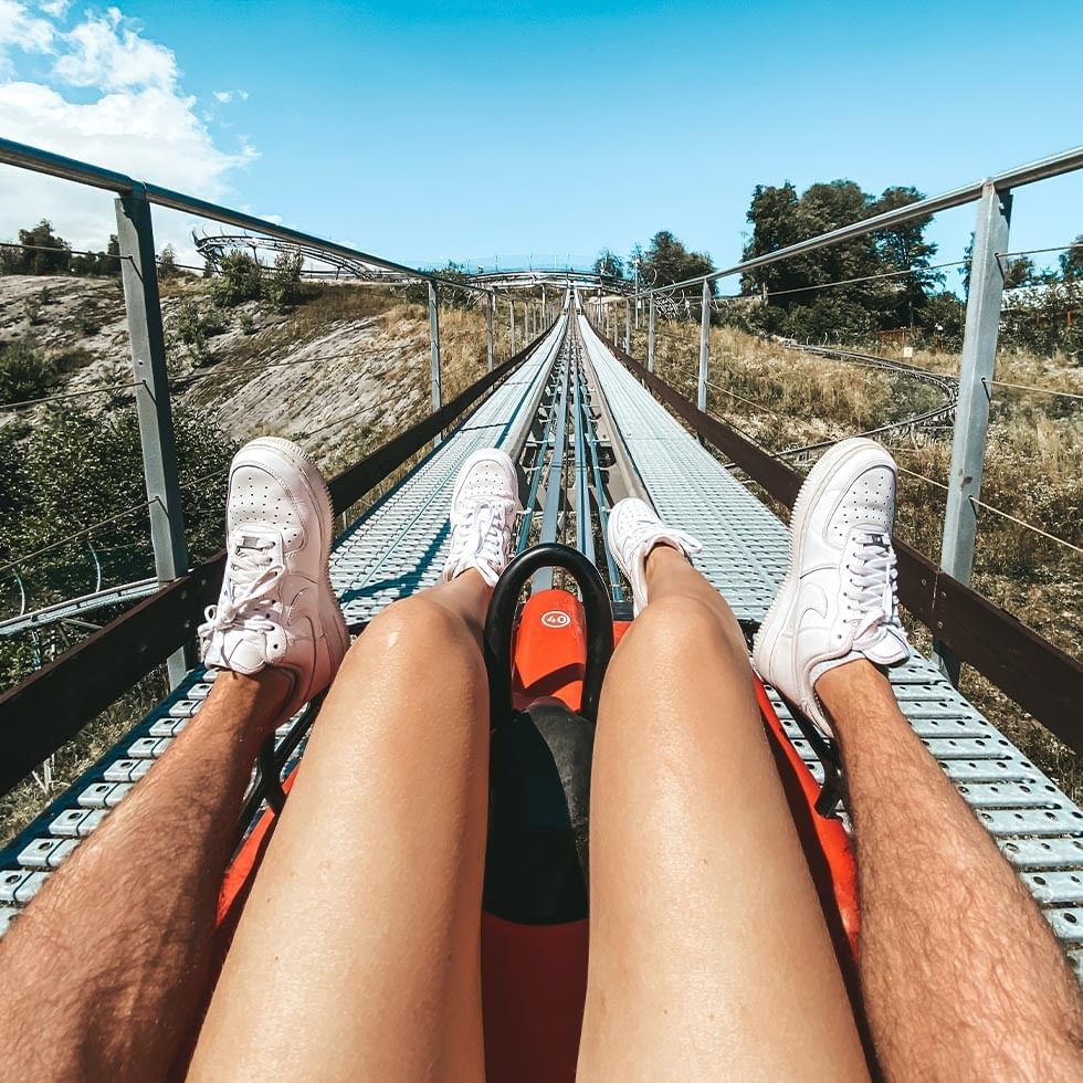 Couple riding a roller coaster on a long track near Falkensteiner Hotel Prague