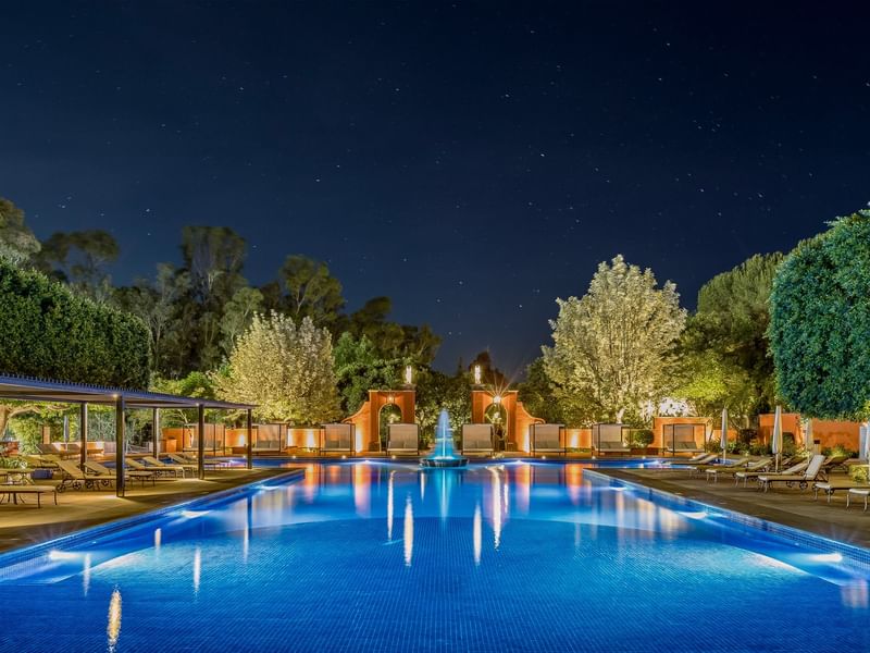 Swimming pool with loungers at night at FA Hotels & Resorts