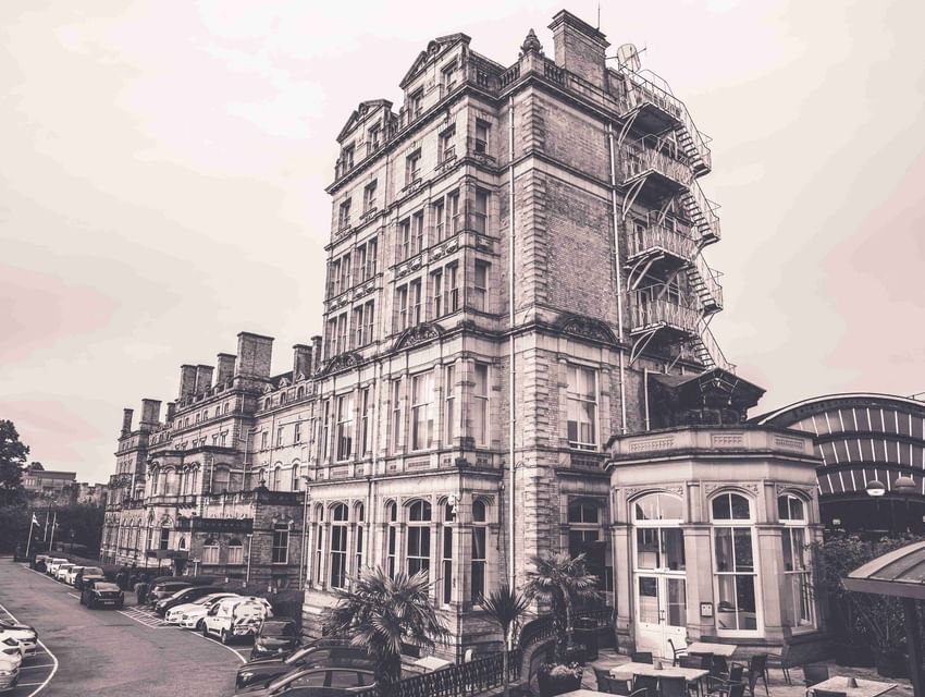 Charming view of The Milner York building with brick and stone facade, exterior staircase, and parking lot in England