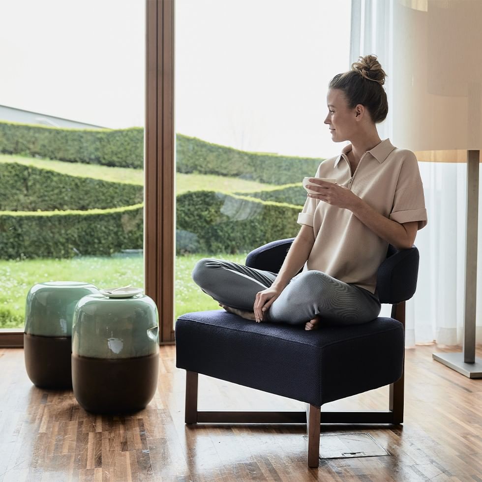 Woman in yoga pose holding a cup in Detox January themed image.