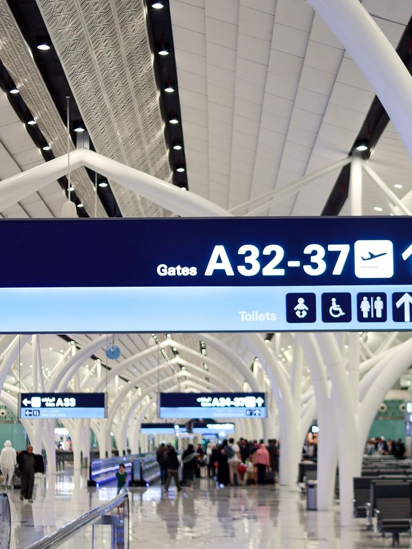 Flight gate directional signage inside modern terminal at King Abdulaziz Airport near Naviti by Warwick Jeddah