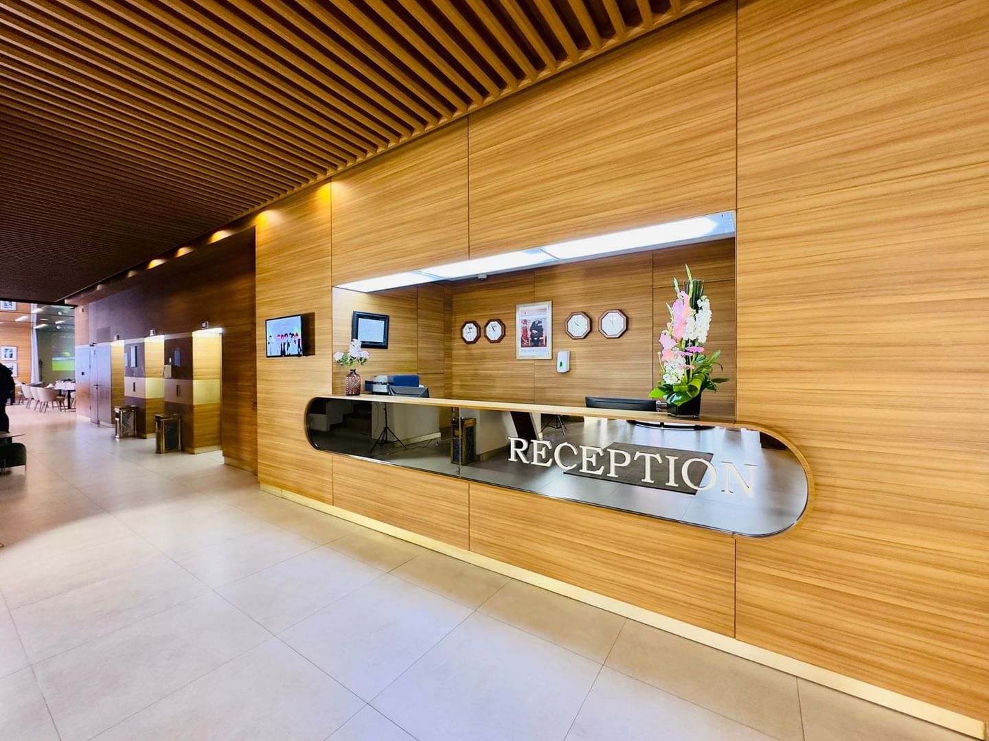 Réception élégante avec comptoir en bois et murs en bois au Kenzi Basma