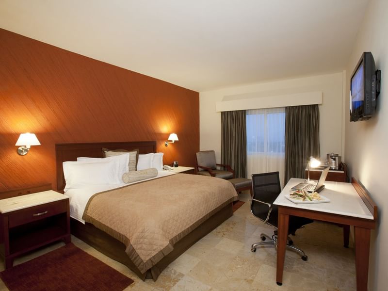 King comfy bed with a TV in Superior Room at Gamma Hotels