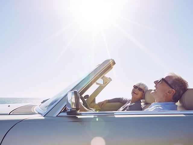 Elderly couple on a convertible near Inn by the Sea at La Jolla