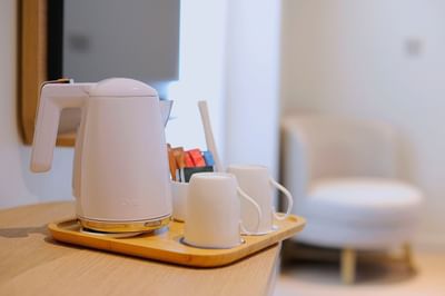 Close-up of electric kettle with mugs on a wooden tray at Cititel Express Kota Kinabalu