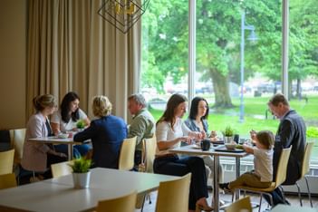 Guests dining by a large window looking outside for the best breakfast in Moncton experience at Rodd Moncton