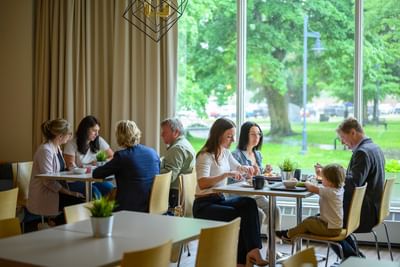 Guests dining by a large window looking outside for the best breakfast in Moncton experience at Rodd Moncton