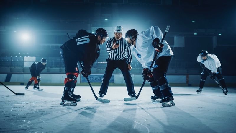 Ice hockey game near The Diplomat Resort, with players facing off and a referee checking the game