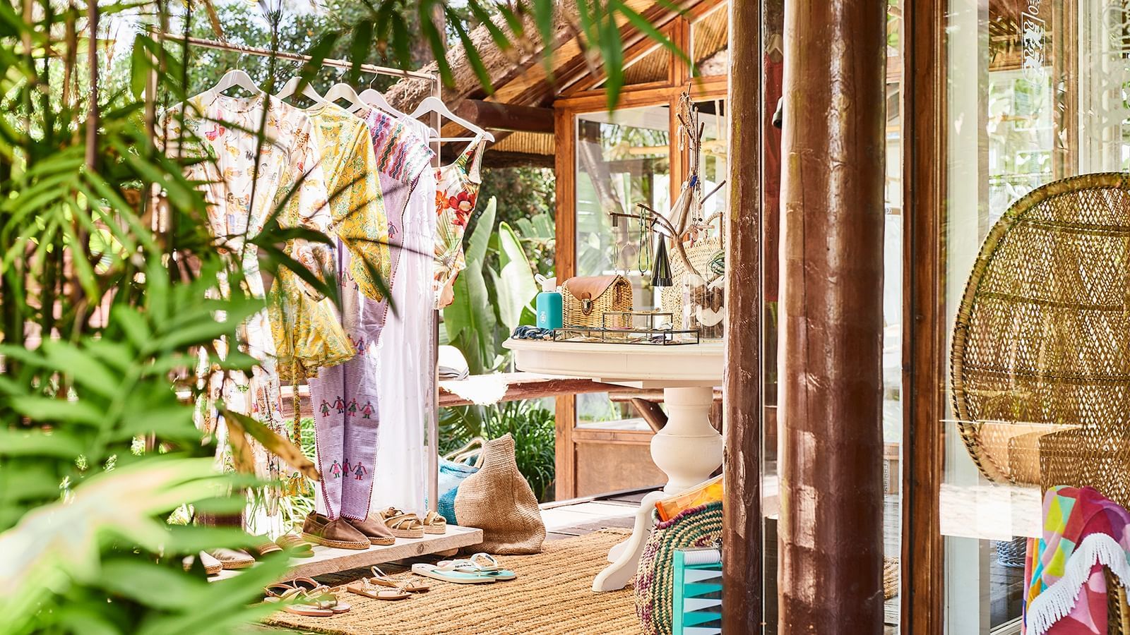 Boutique with clothing hung on racks and jewelry placed on a pedestal table by bamboo at the Marbella Club