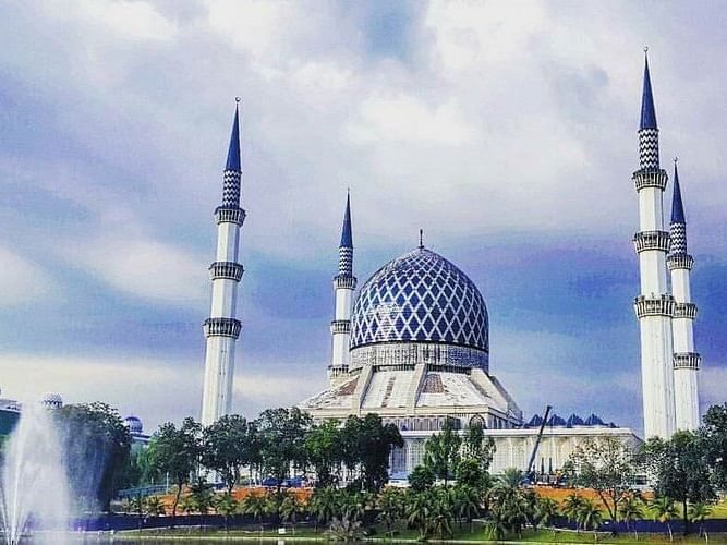 Abdul Aziz Shah Mosque, featuring a blue dome and tall minarets against a cloudy sky near Saujana Hotel Kuala Lumpur