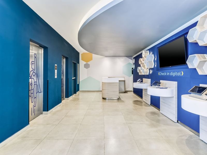 Modern digital check-in area with kiosk at One Acapulco Costera