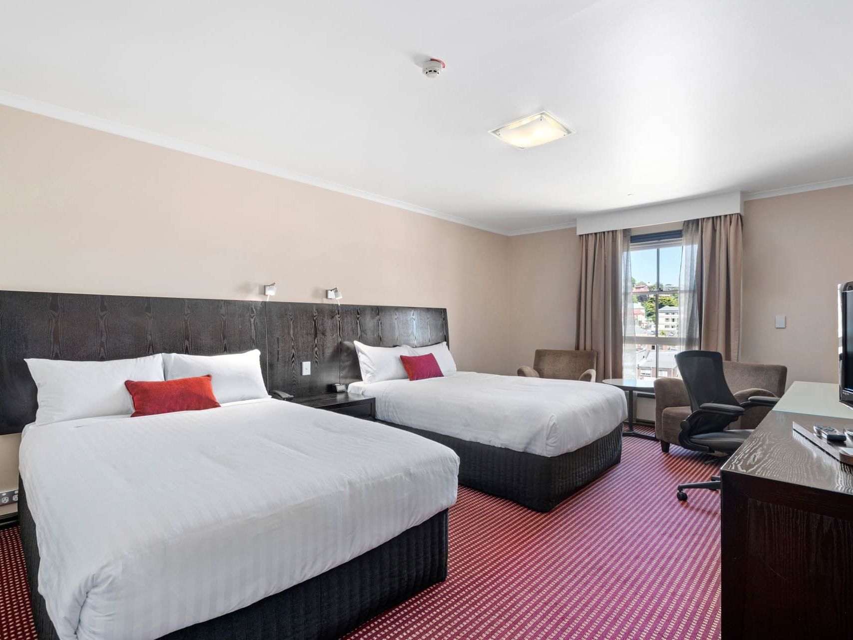 Two beds and sofas arranged by work area in Superior Twin room at Hotel Grand Chancellor Launceston