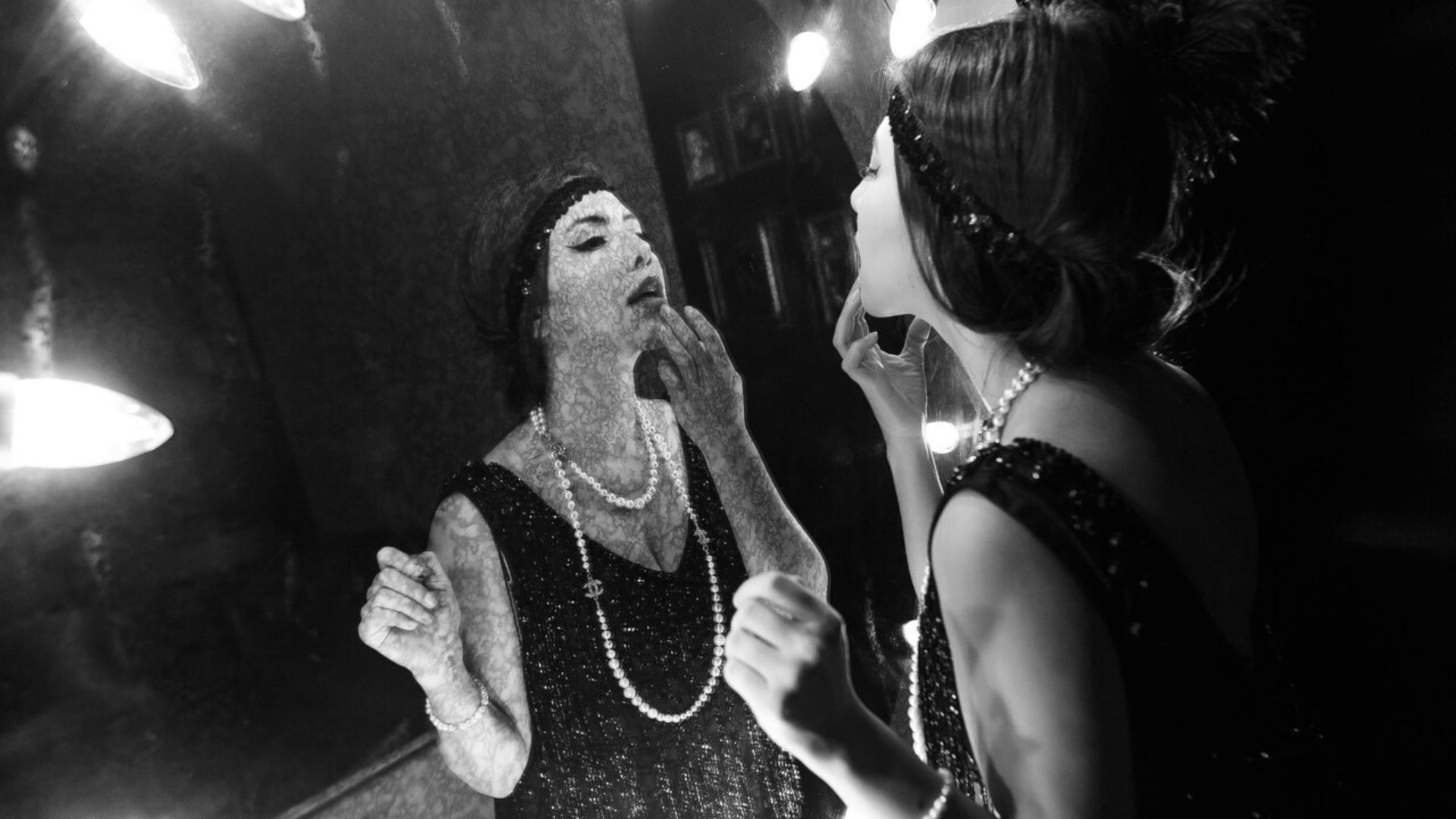 Woman doing make-up in front of a mirror in Flashback Speakeasy Bar & Lounge at Paramount Hotel Dubai