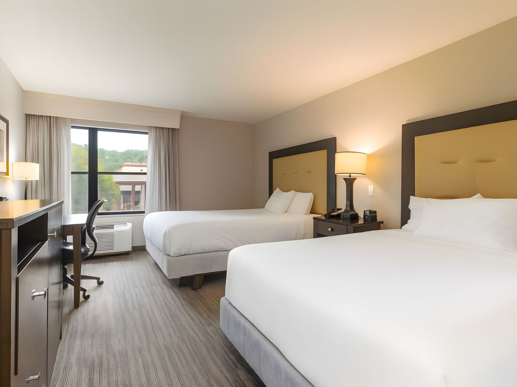 Double Queen Room with two queen beds, dark wood furniture, and a window work desk with a chair at Branson Hillside Hotel