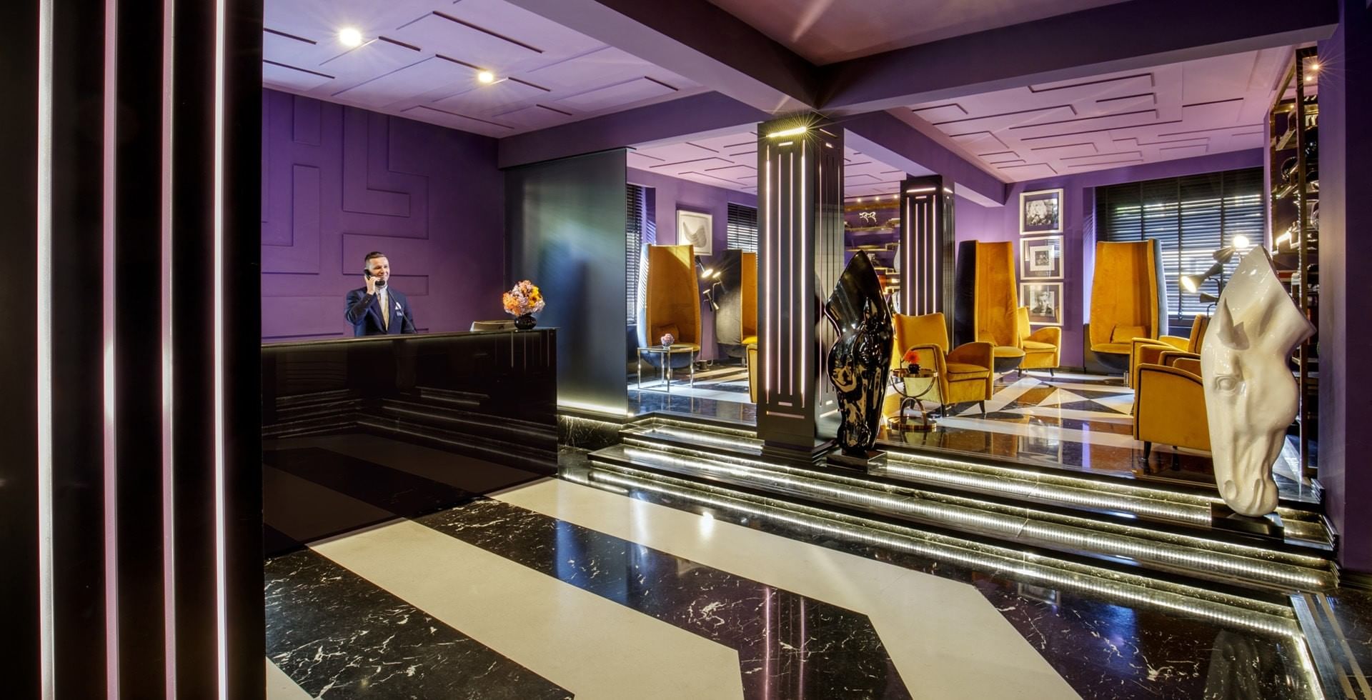 Stylish lobby of Tribune Hotel Rome with modern design, marble floors, contemporary art, and elegant seating area creating a welcoming atmosphere
