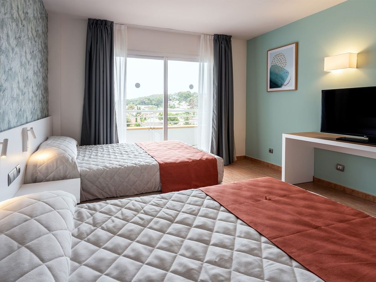 Twin beds, TV and sofa in Junior Suite Rooms at Ponient Pirámide Salou