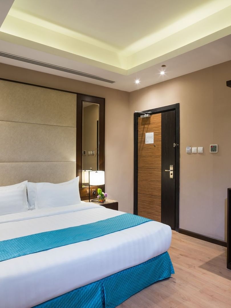 Bed between the side tables and the kitchen cabinet near the door in Standard room at Naviti By Warwick Dammam