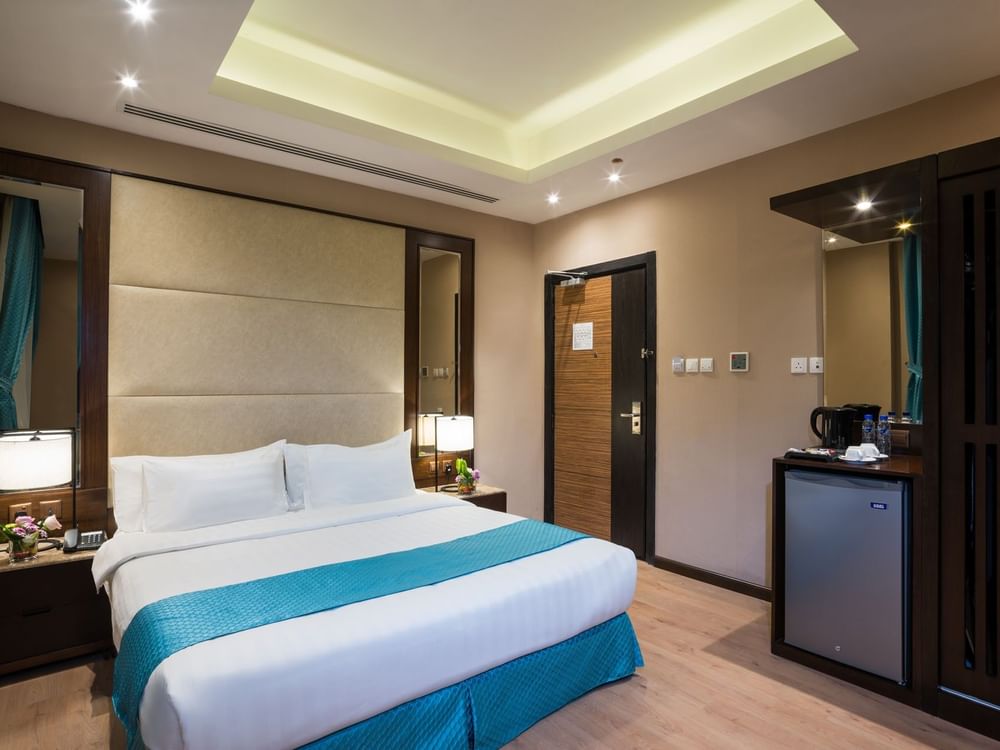 Bed between the side tables and the kitchen cabinet near the door in Standard room at Naviti By Warwick Dammam
