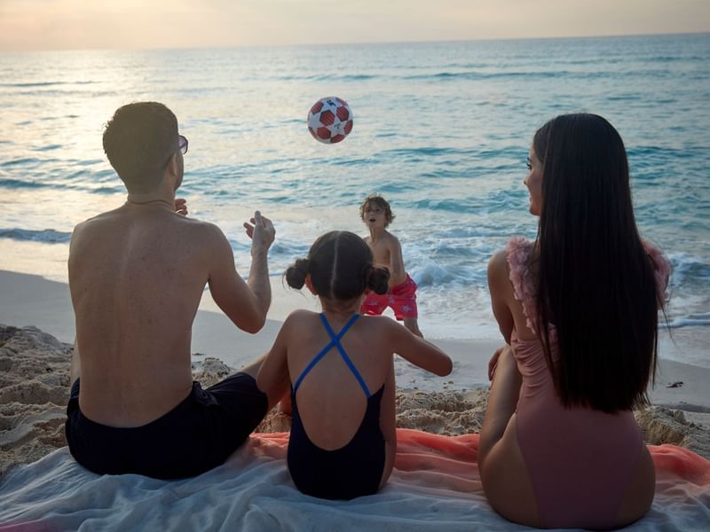 Family enjoying a game of soccer on the sandy beach at Fiesta Americana