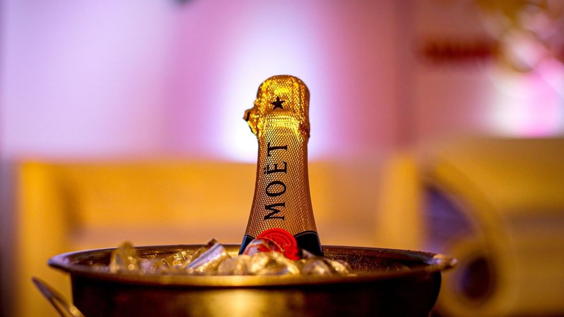 A bottle of Moët champagne chilling in an ice bucket with a festive blurred background for Christmas Day Lunch.