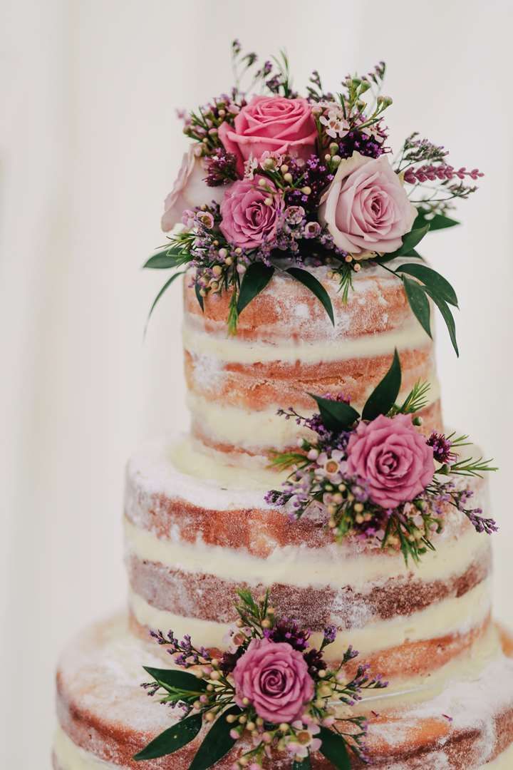 Multi-layered naked cake, adorned with fresh pink and purple roses at The Sebel Mandurah