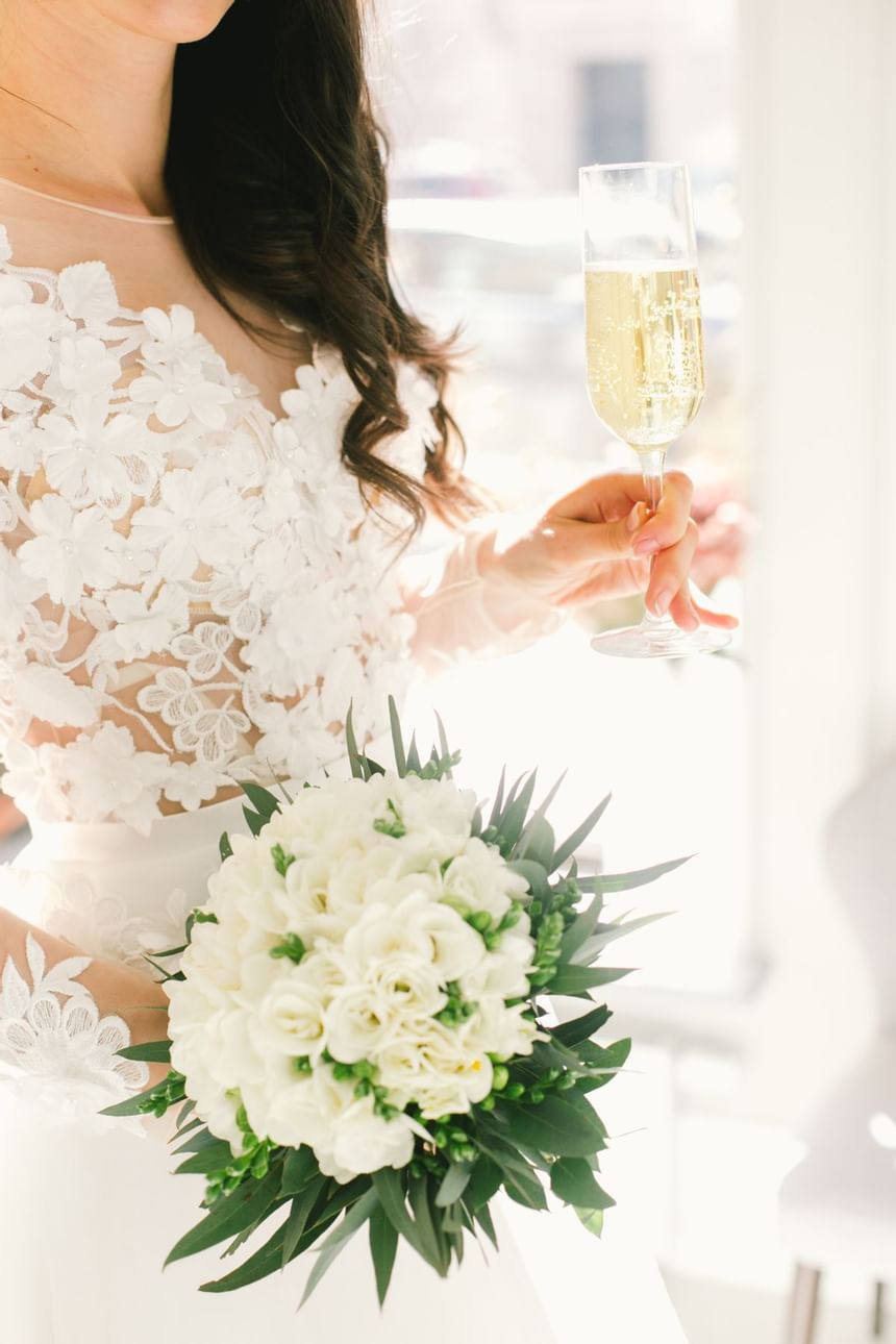 Wedding Bride Holding Champagne and Flowers