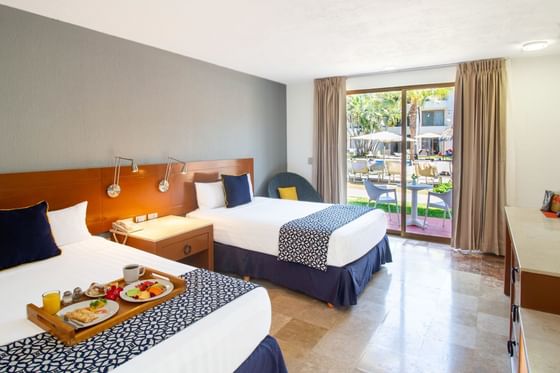 2 comfy beds with an outside view of the terrace in Superior Room at Plaza Pelicanos Club Beach Resort