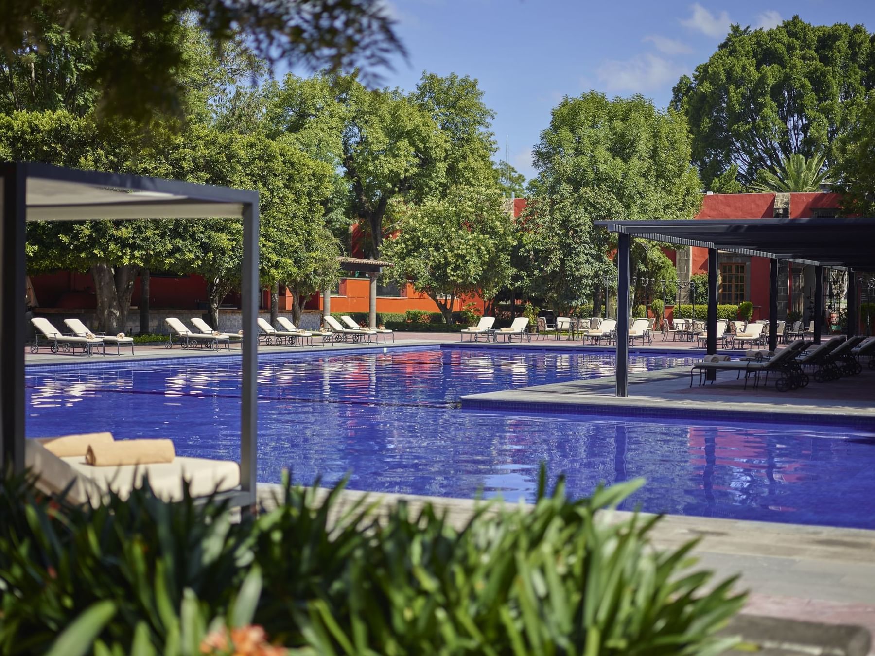 Outdoor pool area with sunbeds at Fiesta Americana Hacienda