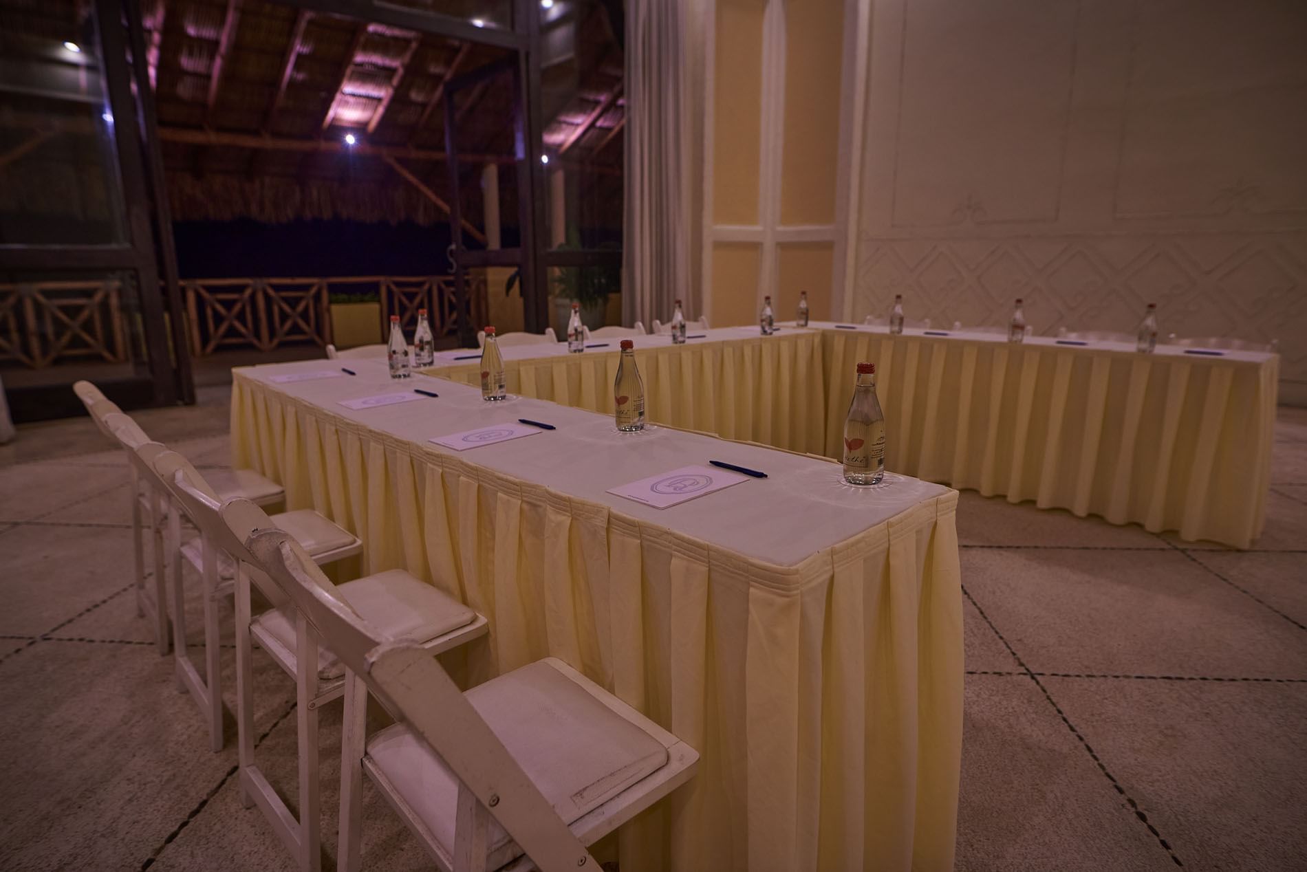 Evening Ixtac Venue setup featuring a U-shaped table arrangement and warm indoor lighting at Quinta Real Acapulco