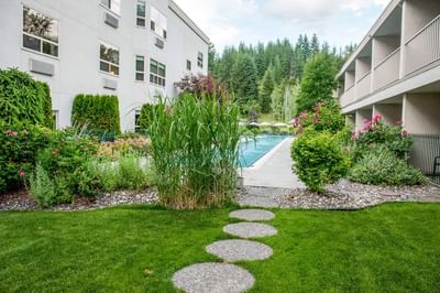 Round stepping stones are across the lawn and the pool at Hilltop Inn Salmon Arm