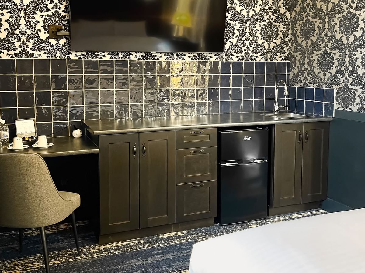 Hotel room with mini fridge, TV, chair, and coffee