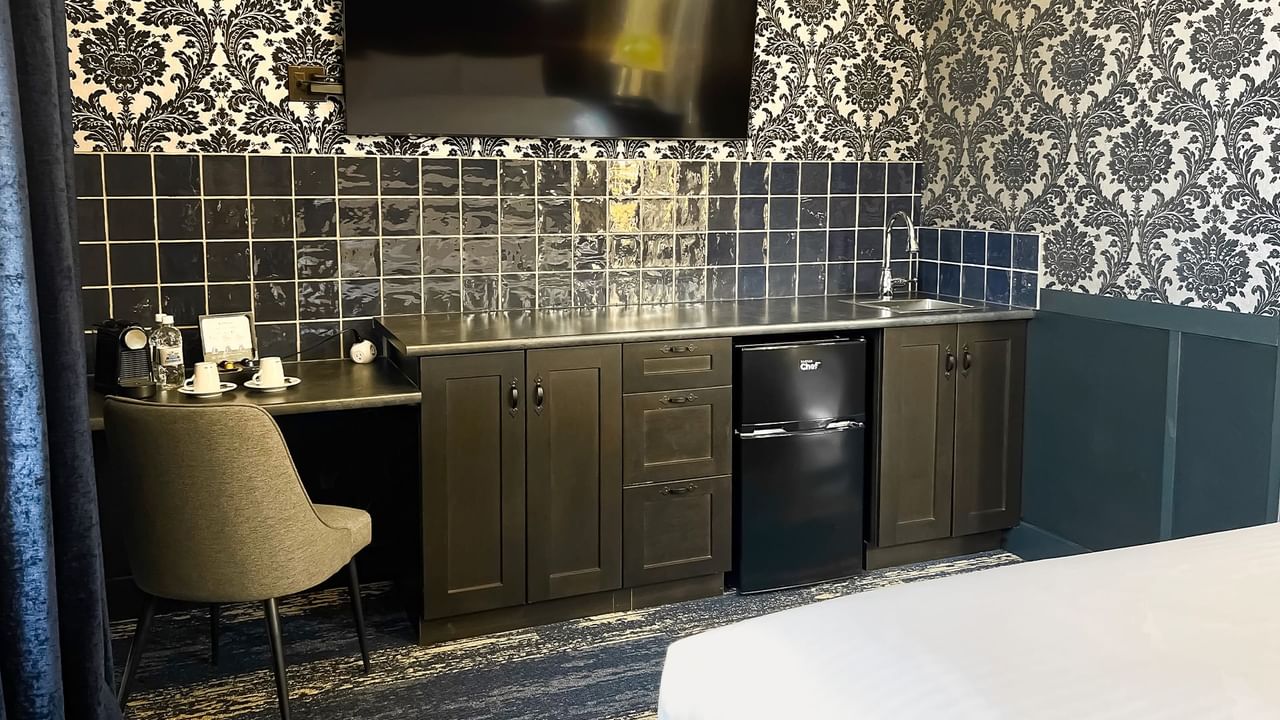 Hotel room with mini fridge, TV, chair, and coffee