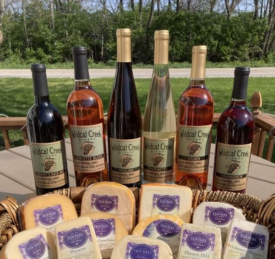 Wildcat Creek wine bottles & cheese on a table, Whittaker Inn