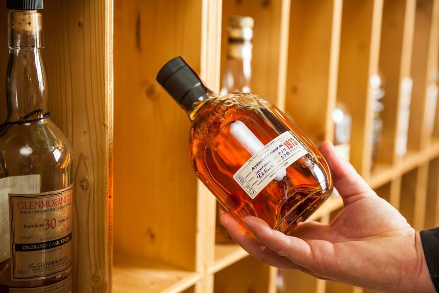 Close-up of a man holding a whiskey bottle at Liebes Rot Flueh