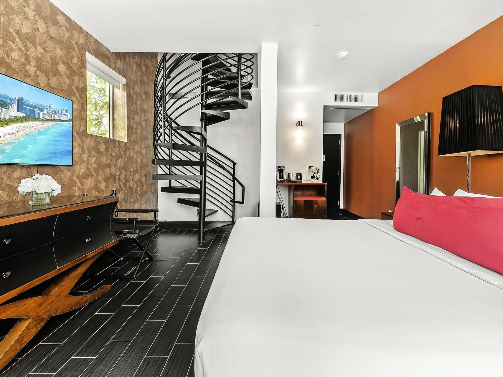 King-size bed, TV, and a spiral staircase to the rooftop in Premium King with Rooftop Terrace at Fairwind Hotel Miami
