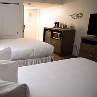 Double guest room with two beds, media stand, microwave, & mini fridge at Bayside Inn Key Largo