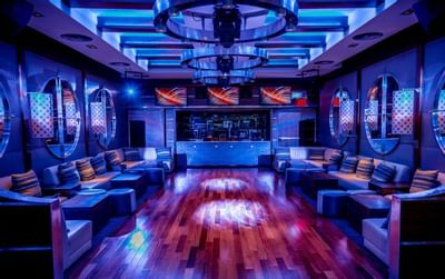 Dance floor area surrounded by couches under circular ceiling lights in Harborside Bar and Lounge at Harborside Inn Boston