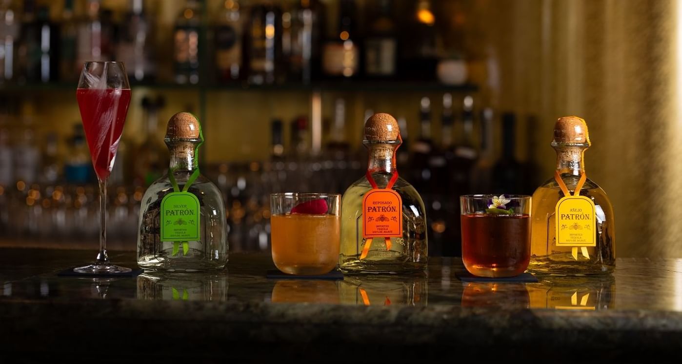 Tequila bottles and cocktail glasses served on a table in the May Fair Bar at The May Fair Hotel