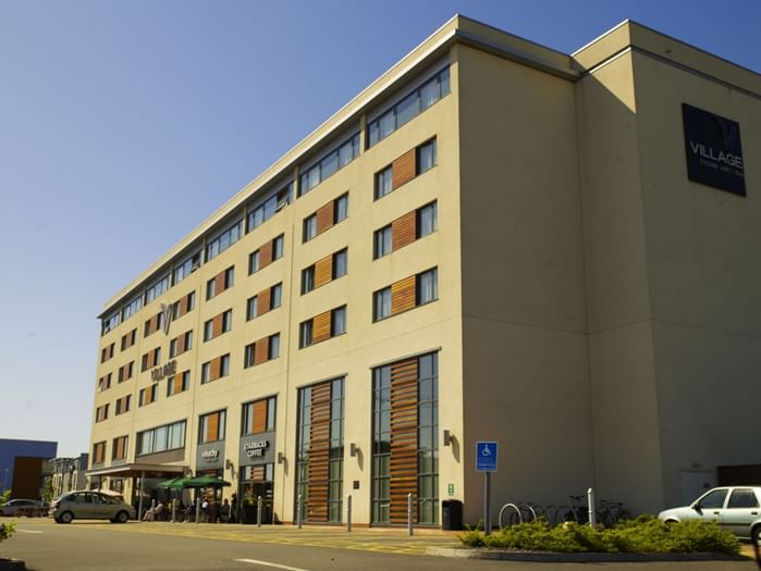 An exterior view of the hotel & car park at Village Hotels