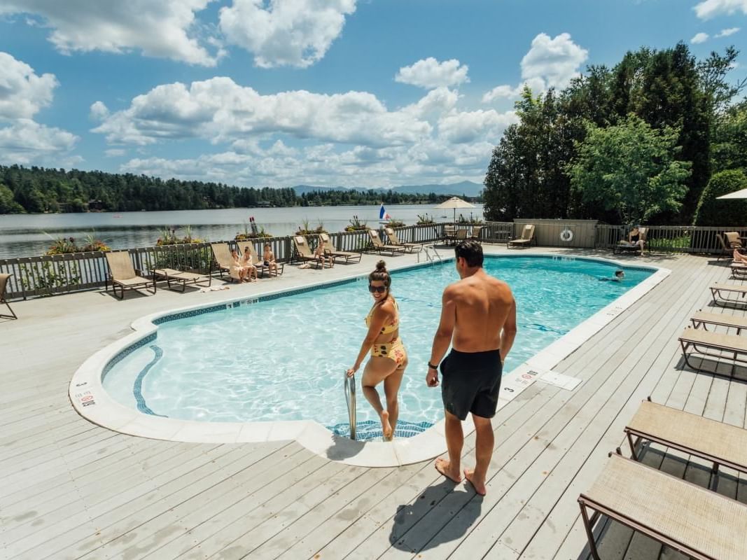 A couple getting into outdoor pool at High Peaks Resort